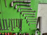 many tools hanging on a green wall in a garage