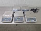 four electronic scales sitting on top of a table in a warehouse