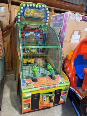un homme debout à côté d'une borne d'arcade dans une pièce