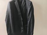 the suit is hanging on a hanger on the wall