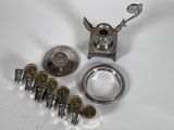 an assortment of silver objects including a teapot, spoon, and other items