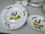 many plates and bowls with roosters painted on them