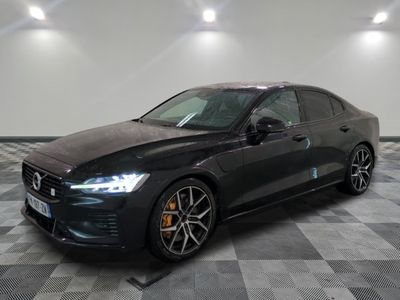 a black car is parked on a checkered floor in a garage
