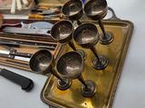 a lot of silver spoons on a tray on a table