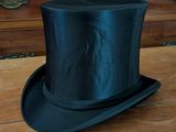 a black top hat sitting on top of a wooden table