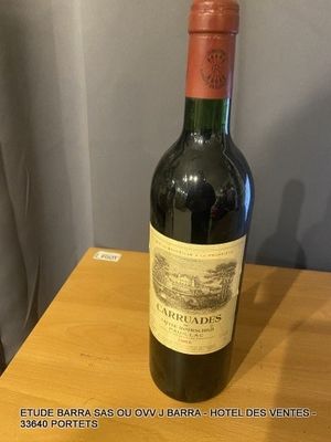 une bouteille de vin posée sur une table à côté d'un rideau