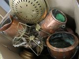 une boîte en carton remplie de casseroles en cuivre et d'une horloge