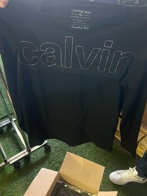 a person standing next to a black t - shirt with the word calvin on it