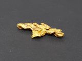 a close up of a piece of gold on a black surface