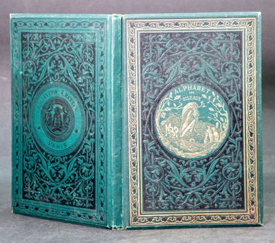 an old book with a green cover sitting on top of a table