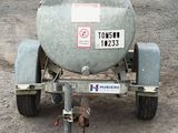 a tank on the back of a trailer in the dirt