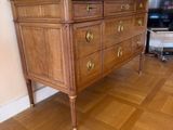 une commode en bois avec un plateau en marbre dans un salon