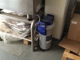 a refrigerator that is sitting next to a pallet of boxes