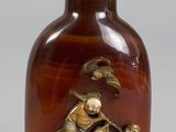 une bouteille en verre brun ornée d'un motif doré