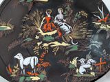 a black plate with a picture of a woman and animals on it