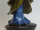 statue of a woman holding a flower in her hand on a blue base