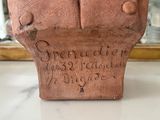 a brown vase with writing on it sitting on a table