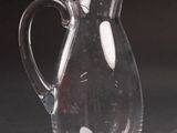 a glass pitcher sitting on a table with a black background