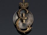 a close up of a gold and silver broochle with a crown on it