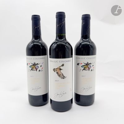 trois bouteilles de vin rouge sont alignées sur une surface blanche
