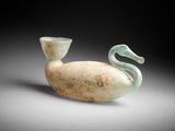 un vase en verre blanc et vert posé sur une table