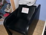 une chaise noire sur laquelle est posé un lavabo blanc