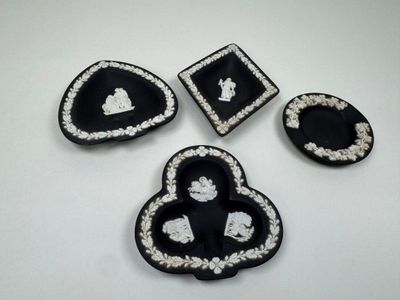 four pieces of black and white brooches on a white surface
