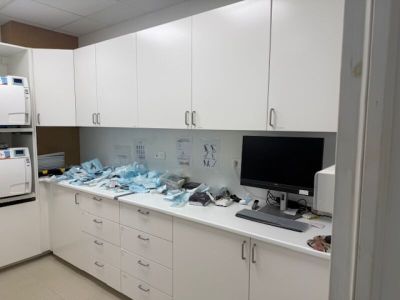 a white kitchen with white cabinets and a computer on the counter
