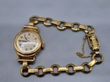 l'image d'une montre-bracelet en or entourée d'une chaîne