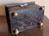an old suitcase sitting on a table with a tag on it