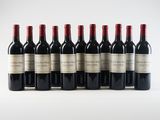 six bottles of red wine lined up in a row on a white surface