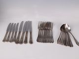 a lot of silverware sitting on a white table