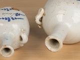 two white vases with blue designs on them sitting on a table