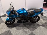 a blue motorcycle that is parked on a checkered floor