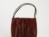 un sac à main en velours rouge avec une anse en cuir