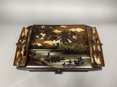an old wooden box with a painting on it sitting on a table