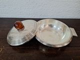 a silver plate with a brown stone in it on a wooden table