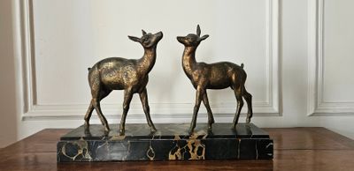 deux statues de cerfs posées sur un socle en marbre
