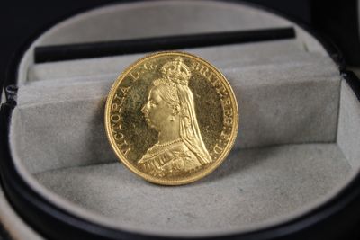 une pièce d'or posée dans une boîte sur une table