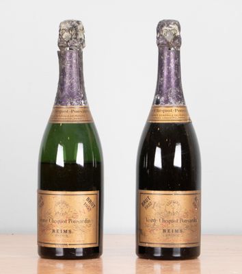 two bottles of champagne sitting on top of a table next to each other