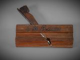 an old wooden box with a knife on top of it