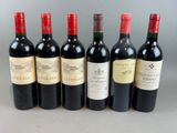 six bottles of wine lined up in a row on a table