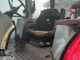 un tracteur rouge qui se trouve à l'arrière d'un camion