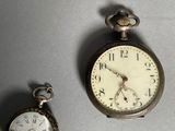 two clocks sitting next to each other on a table