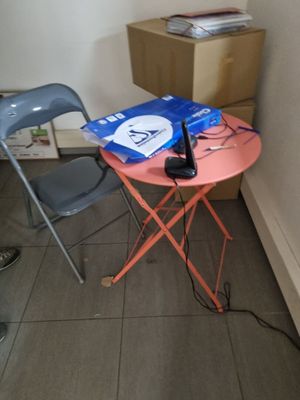 une petite table sur laquelle est posé un téléphone portable, à côté d'une chaise