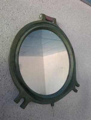 a round mirror hanging on the side of a building