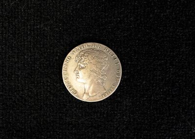 an image of a coin on a black surface with a black background