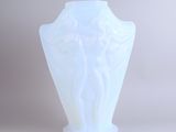 a white vase that has a statue on it