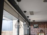 une pièce avec un mur en briques et plusieurs lampes suspendues au plafond