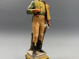 statue d'un soldat muni d'un fusil et portant un chapeau, posée sur un socle